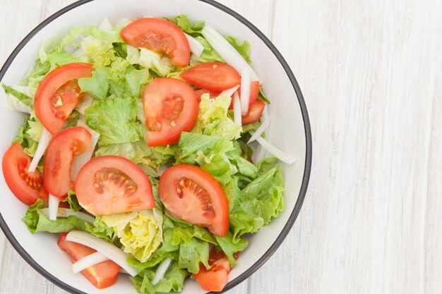 Saladekom op een witte houten achtergrond