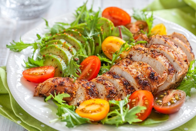 Saladeplaat met kleurrijke tomaten, kipfilet en avocado