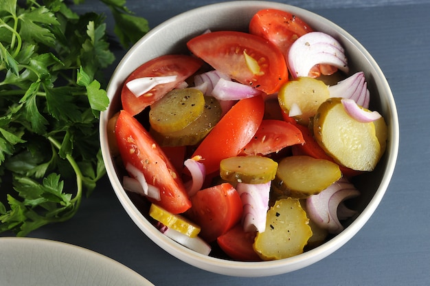 Saladevoorgerecht met tomaten, groenten in het zuur en uien