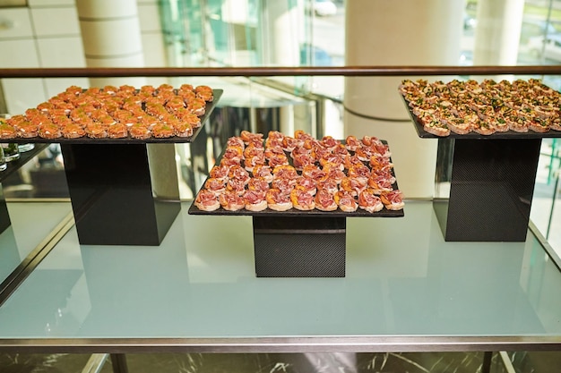 Salads in cups and canapes on trays