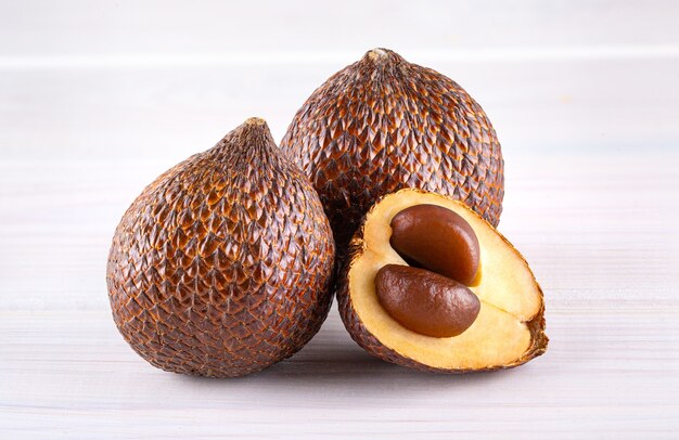 Salak (Salacca zalacca) 또는 나무 배경에 고립 된 뱀 과일