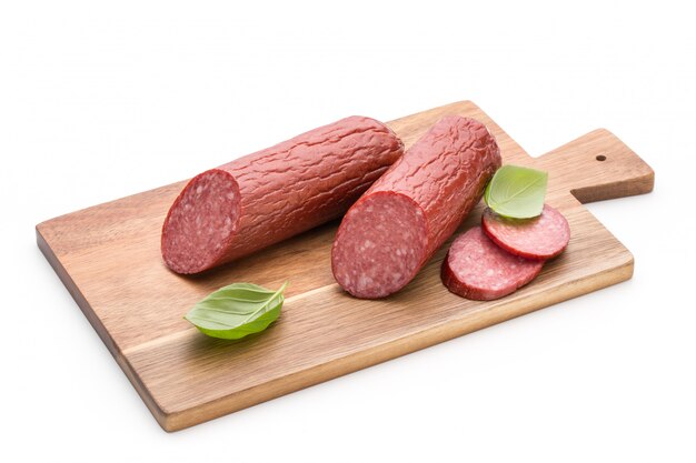 Salami gerookte worst, basilicumbladeren op wit ruimte knipsel.