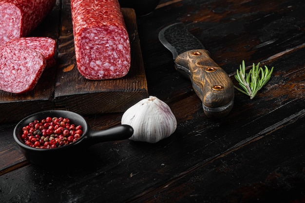 Salami met ingrediëntenset, op oude donkere houten tafelachtergrond, met kopieerruimte voor tekst