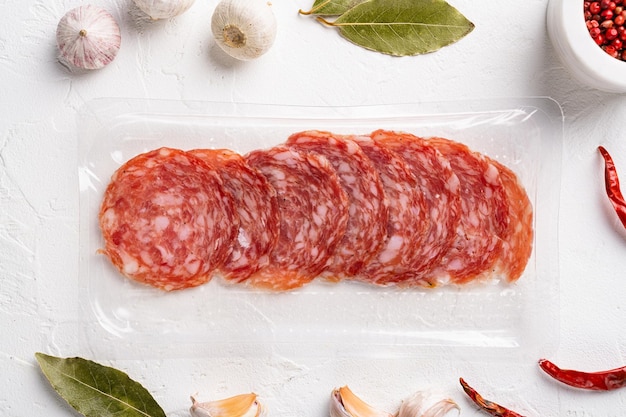 Salami Milano pack Italiaanse worst set, op witte stenen tafel achtergrond, bovenaanzicht plat lag