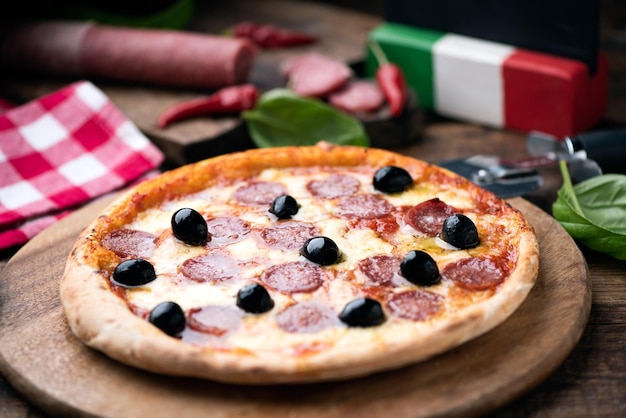 A salami pizza on wooden table