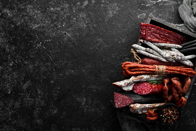 Salame, salsicce, spezie e prodotti a base di carne in una scatola di legno vista dall'alto spazio libero per il testo