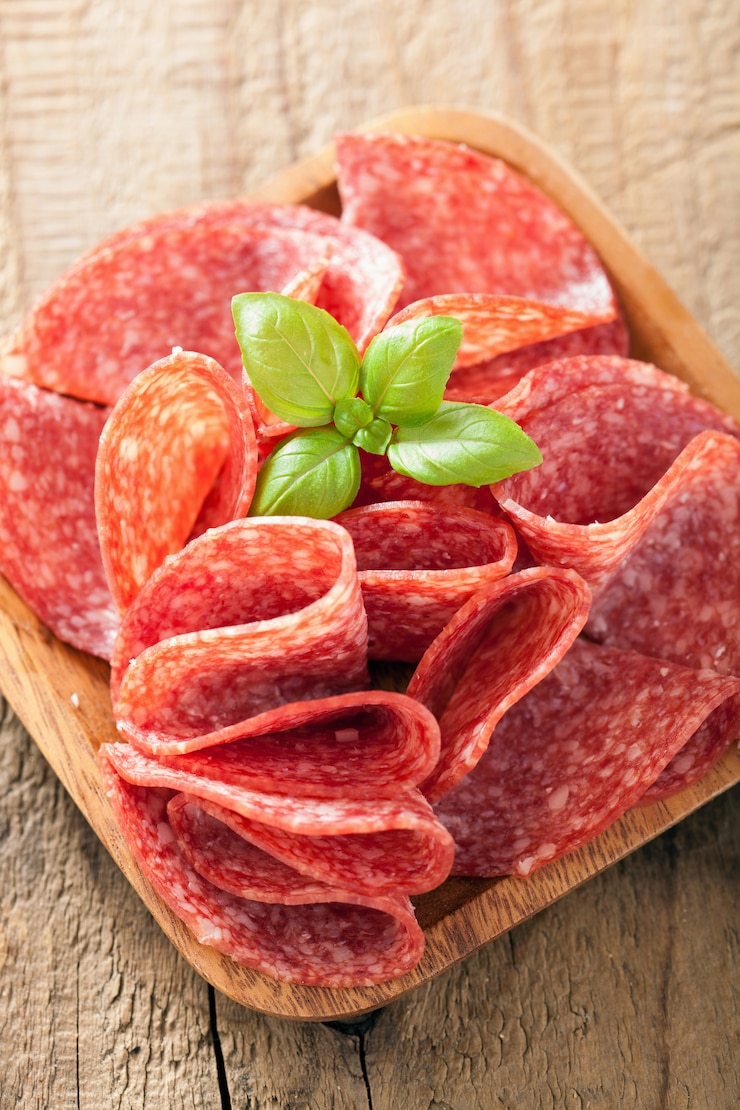 Photo salami slices in wooden plate