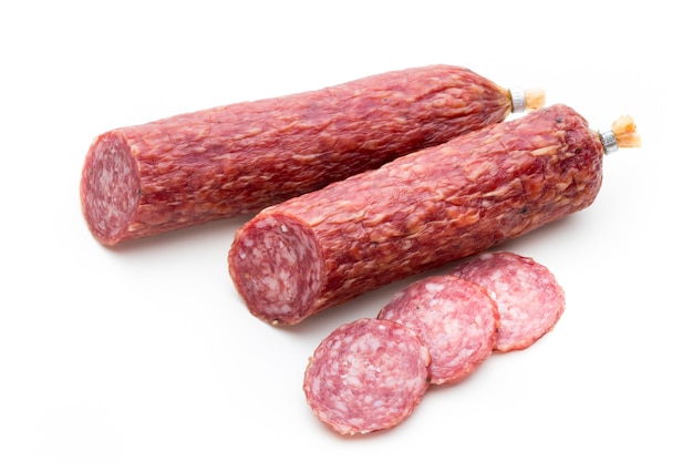 Salami smoked sausage, basil leaves and peppercorns isolated on white surface.