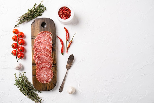 Salami smoked sausage set, on white stone table background, top view flat lay, with copy space for text