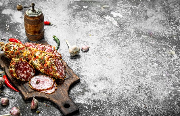 Salami with spices and herbs. On a rustic background.