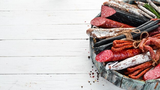 Salami worstjes specerijen en vleeswaren in een houten kist Bovenaanzicht Vrije ruimte voor uw tekst