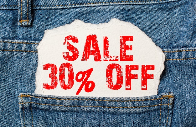 Sale 30 off on white paper in the pocket of jeans