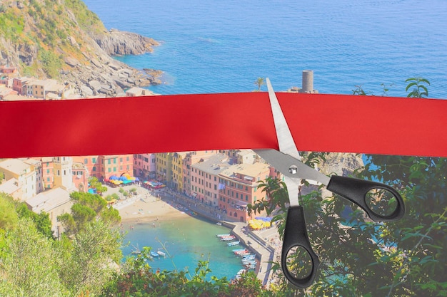 Sale of airline tickets Scissors cut the red ribbon overlooking the picturesque village of Vernazza Italy