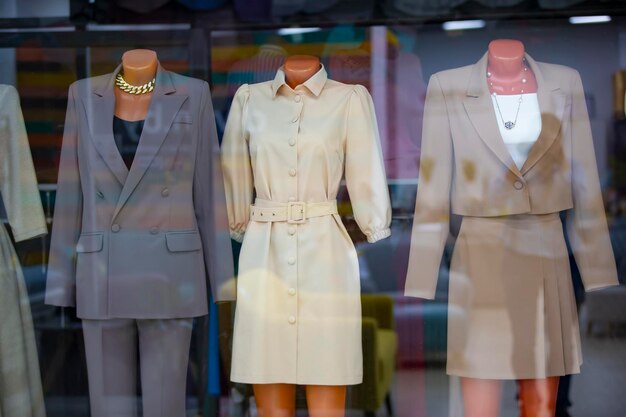 Sale of clothes for women behind the glass of a shop window are\
mannequins in women\'s clothing