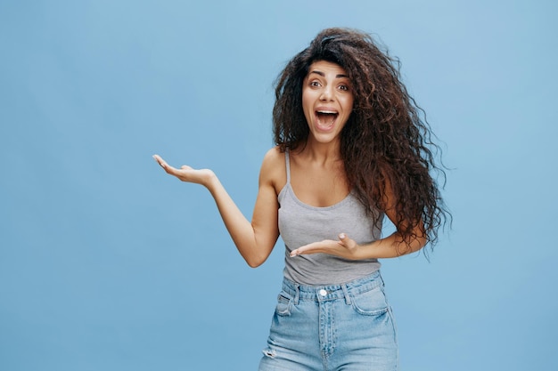 Sale jeans offer excited beautiful latin female with afro say
look at this look at camera show copy space free place for design
ad fashion studio shoot over blue sky background