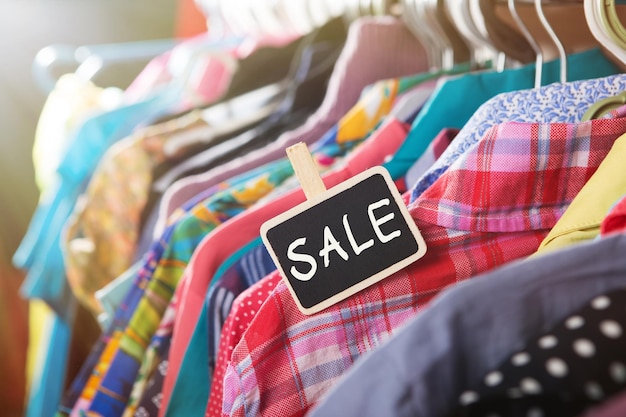 sale label clothes hanging on the rack in the fashion store