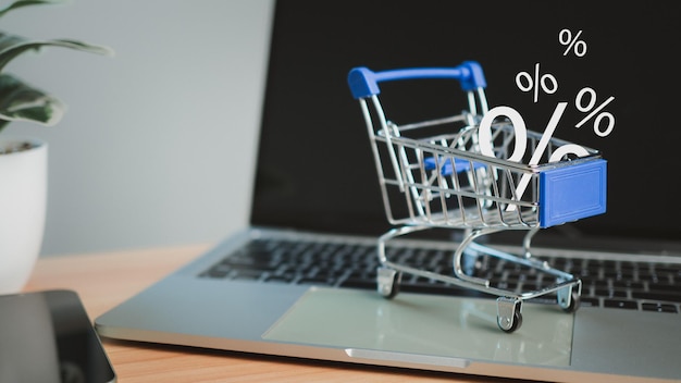 Photo sale percentage falling in shopping cart located on a computer keyboard online shopping concept