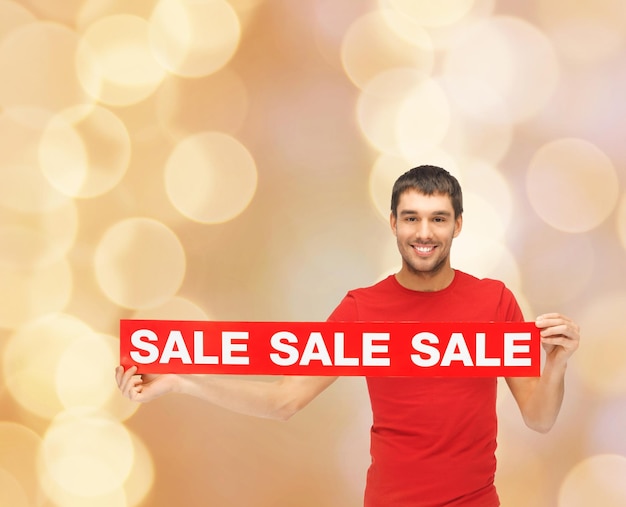 판매, 쇼핑, 크리스마스, 휴일 및 사람 개념 - 판매 기호가 있는 빨간색 티셔츠를 입은 웃는 남자