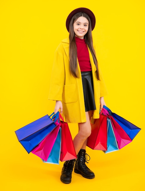 Sale and shopping concept Teen girl holding shopping bags isolated on studio background Happy