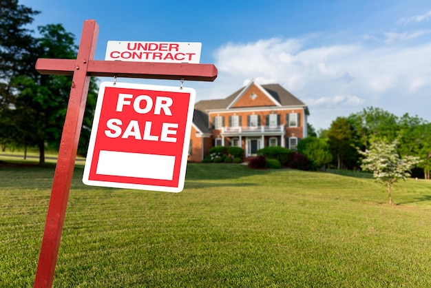 For sale sign in front of large USA home