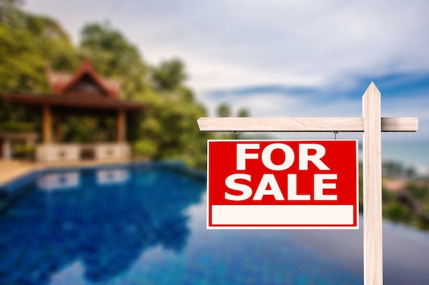 For sale sign at luxury house with pool background