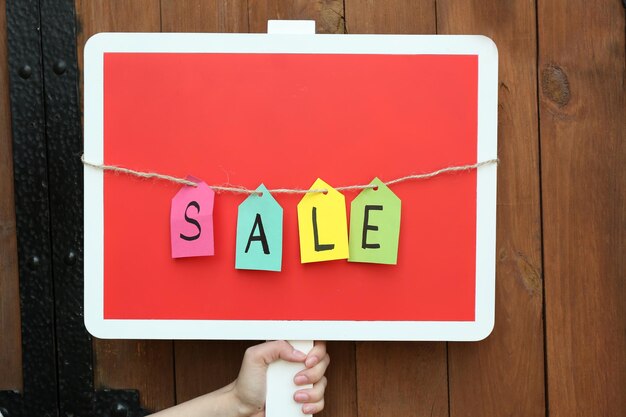 Sale sign on wooden fence background