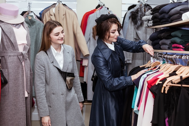 若い女性の買い物袋を笑顔の販売