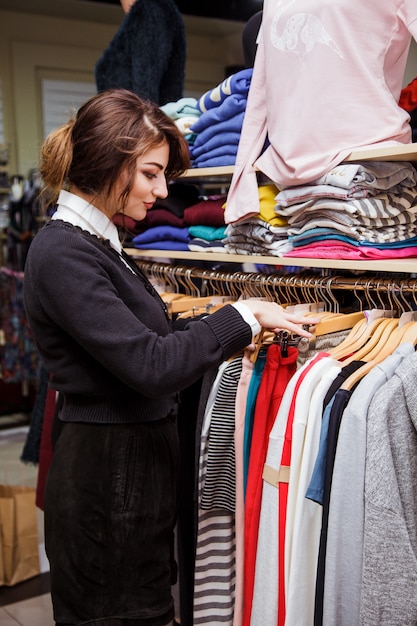 若い女性の買い物袋を笑顔の販売