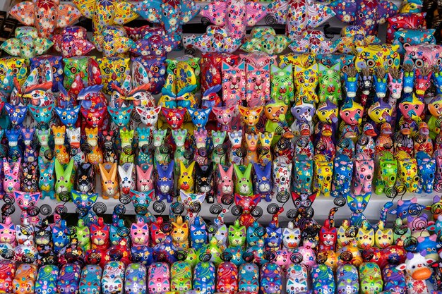 Sale of souvenirs - funny handmade wooden animals in street market. Bright colorful children toys and decoration for interior. Ubud, Bali island, Indonesia. Close up