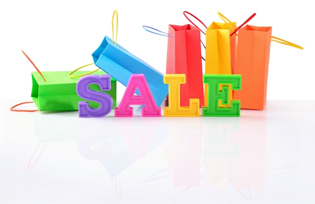 Sale written by colorful letters on the background of shopping bags