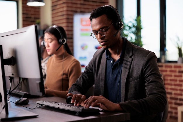 Sales consultant working at call center client care on phone line, using telemarketing equipment. Customer service operator giving support and assistance on helpline telephony network.