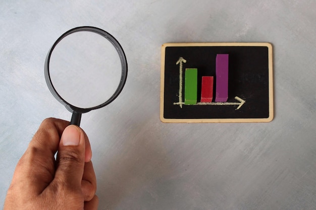 Photo sales graph chart on chalkboard and magnifying glass business and sales analysis concept