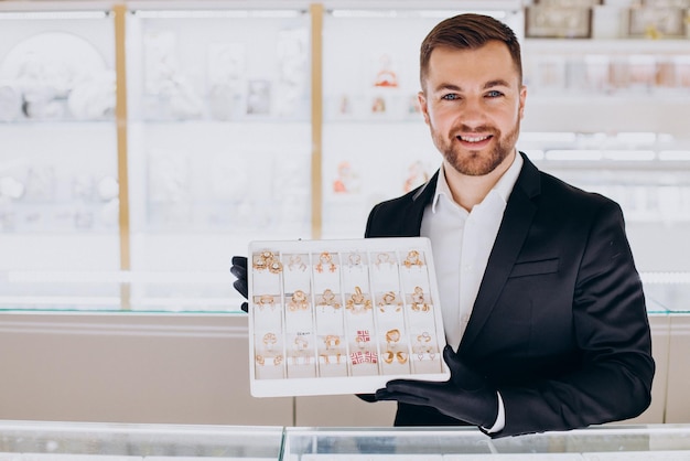 Foto addetto alle vendite in gioielleria che dimostra gioielli