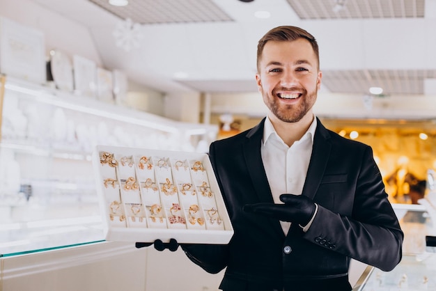 Sales man at jewelry shop demonstrating jewellery