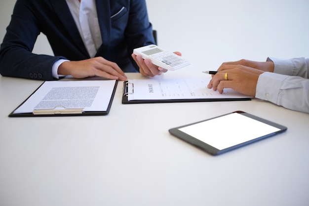 Sales manager giving advice application form document, considering mortgage loan offer for car and house insurance.