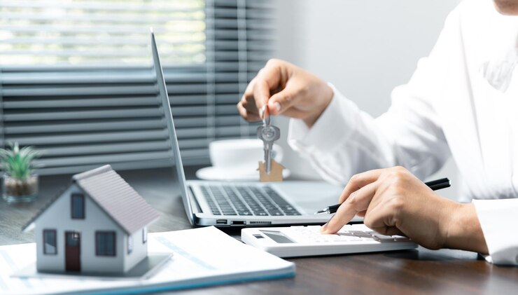 Photo sales manager or real estate agent prepares to hand over the keys and the house together with the insurance to the customer attention to property services and insurance concept