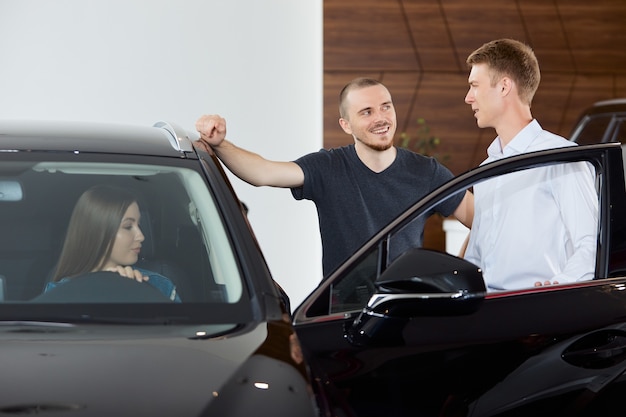 A sales representative explains the pros and cons of a brand new car at a dealership