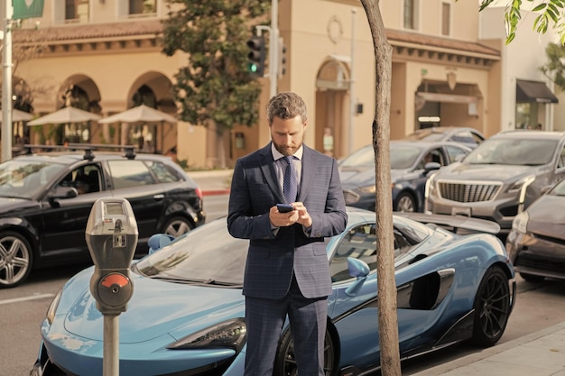 Salesman chatting on mobile phone rich guy rent car