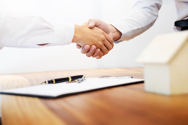 Photo salesman doing handshake with customer at desk