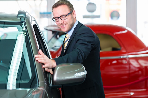 Salesman selling car at dealership