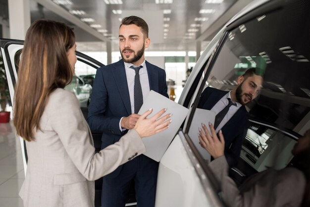 Продавец, продающий автомобили в автосалоне