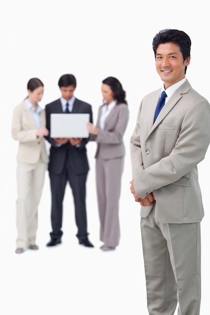 Salesman with colleagues and laptop behind him