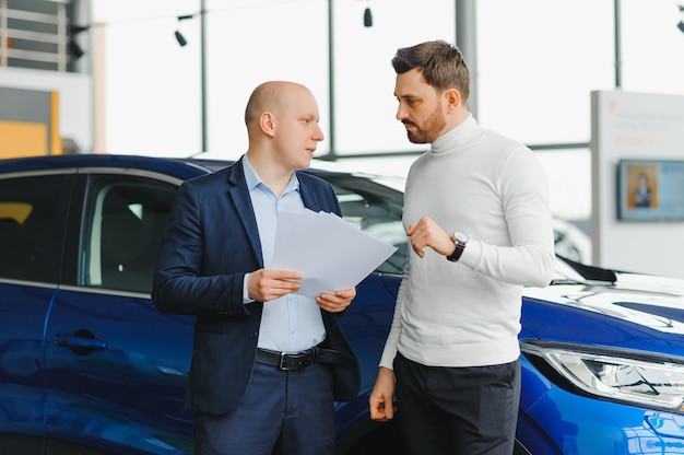 Salesperson selling cars at car dealership