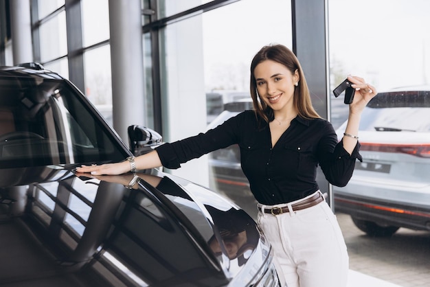 saleswoman showing car keys in a dealership