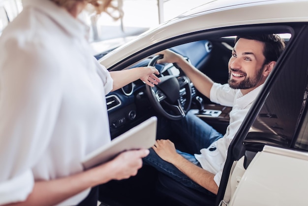 Saleswoman talking with client in dealership salon