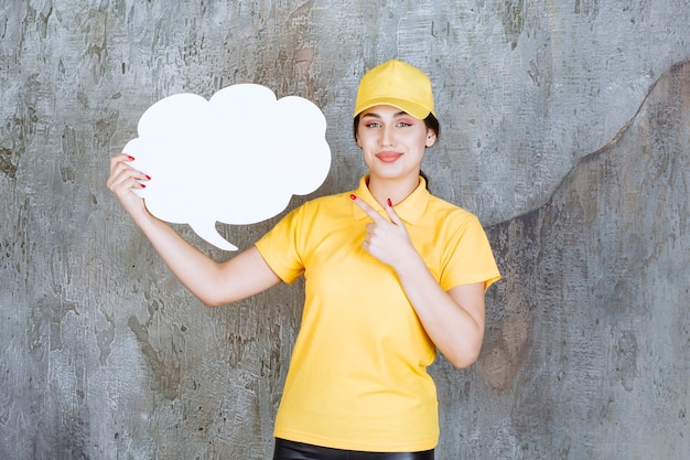 A saleswoman in yellow uniform holding a cloud shape info board and showing positive signs