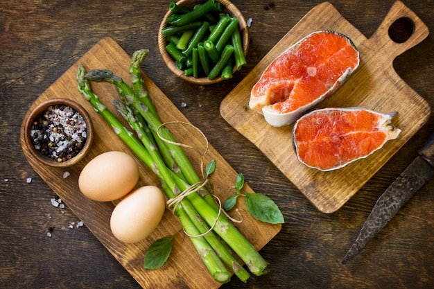 Salmon asparagus and eggs on wooden background Top view flat lay  Free space for your text