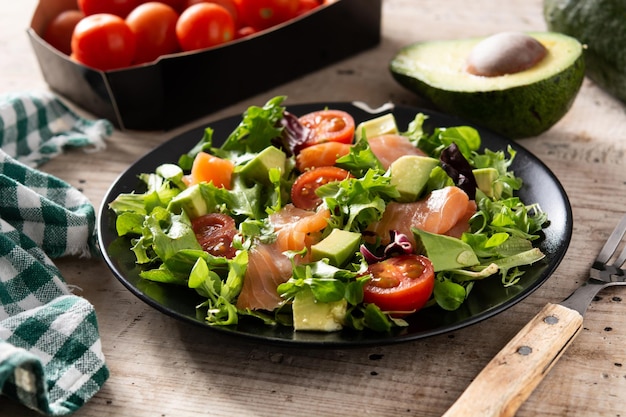 Salmon and avocado salad on rustic wooden table