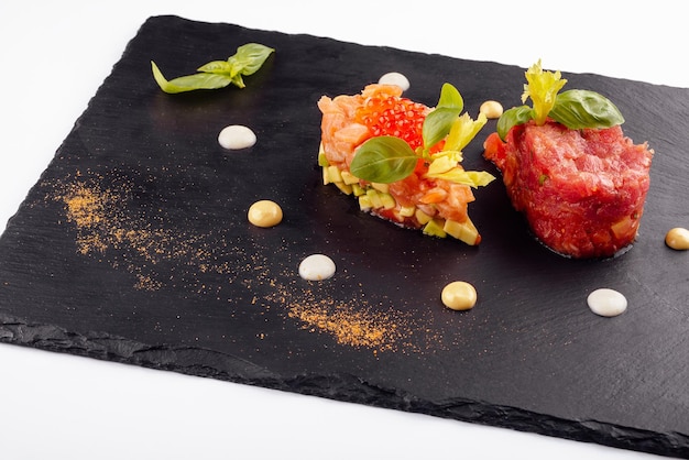 Salmon and beef tartare on black board