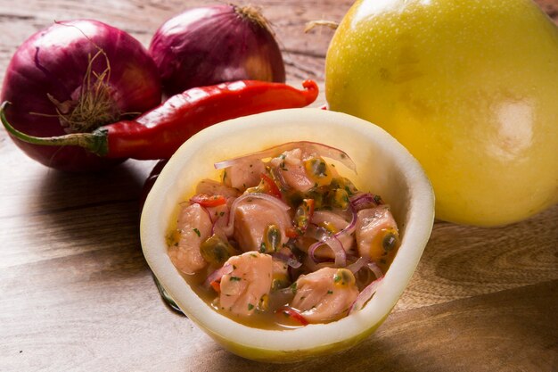 Salmon ceviche with passion fruit sauce on wooden background